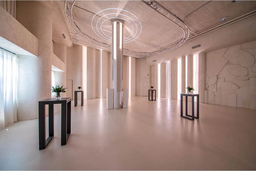 Sala blanca con iluminación de diseño y mesas con flores
